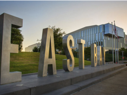 Image of the East Bay's metal letters that spell out "East Bay" in front of the lawn